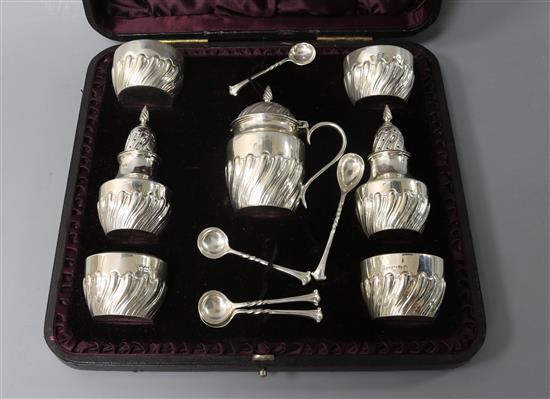 A cased Victorian repousse silver seven piece condiment set by James Deakin & Sons Ltd,